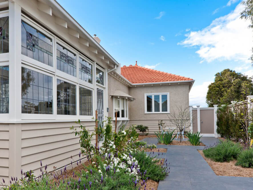 Cream Side Exterior with Tiled Black Pathway and White Window Trims Detailed Glass and Garden